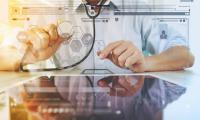 Udsnit af mandlig læge (ansigt ikke synligt) sidder foran tablet, en grafisk illustration af en internetbrowser og diverse ikoner er redigeret ind over billedet for at illustrere brugen af digital teknologi i sundhedsvæsnet. 